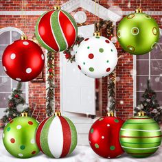 there are many christmas ornaments hanging from the ceiling in front of a brick wall and door