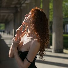 a woman with red hair is posing for the camera