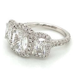 an engagement ring with three stones and diamonds on the sides, set in white gold