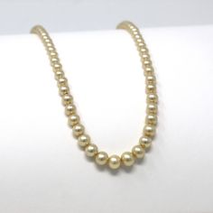 "Pretty vintage circa 1940s era 14k yellow gold simulated pearl necklace! This lovely necklace is comprised of graduated simulated pearl beads in off white, with a 14k yellow gold fish hook clasp. A classic 1940s era fashion accessory, featuring June's birthstone! *Sale - price reduced from $195 USD to $175 USD.  ERA - Circa 1940s - Retro METAL / MATERIAL - 14k yellow gold, simulated pearls MARKINGS / HISTORY - Clasp is marked \"14K A\" CONDITION - Good vintage condition. Yellow gold metal has b Classic Gold Single Strand Pearl Necklace, Classic Gold Pearl Necklace, Vintage Yellow Gold Single Strand Necklace, Classic Gold Pearl Necklace For Formal Occasions, Gold Pearl Necklace For Formal Occasions, Classic Gold Pearl Necklace With Round Beads, Classic Gold Pearl Necklace For Anniversary, Antique Gold Pearl Necklace For Formal Occasions, Vintage Single Strand Gold Pearl Necklace