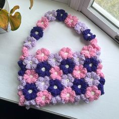 a crocheted purse sitting on top of a window sill