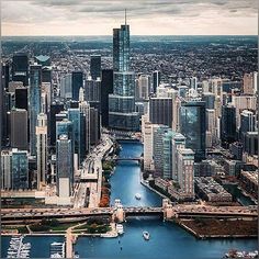 an aerial view of a city with boats in the water and tall buildings on both sides