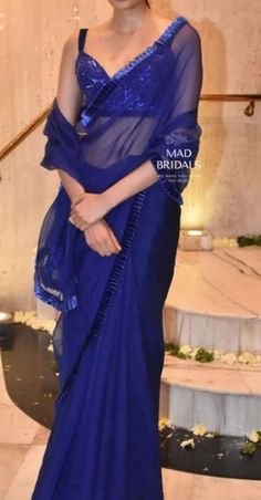 Elevate your style with our stunning Royal Blue Organza Silk Saree. It comes with a beautifully detailed border, and the blouse is hand-embellishments with sequins and stones for that extra touch of elegance. It comes with a stitched blouse according to your measurements This ensemble is perfect for making a statement at any event. Don't miss out on adding this touch of luxury to your wardrobe!  Unveiling the Details: Color: Royal Blue Craftsmanship: Masterful Handwork Fabric: Pure Organza  **Important Notes All our items are meticulously handmade and uniquely tailored for our valued customers. Expect minor variations in the actual product compared to the displayed image. Product color may slightly vary due to photographic lighting sources or your monitor settings. Please be advised that o Blue Pre-draped Saree With Pallu For Wedding, Tissue Silk Pre-draped Saree With Dupatta, Unstitched Gota Work Pre-draped Saree, Elegant Blue Pre-draped Saree With Dori Work, Traditional Gota Work Pre-draped Saree, Bollywood Style Floor-length Pre-draped Saree With Gota Work, Floor-length Pre-draped Saree With Gota Work For Diwali, Elegant Blue Dola Silk Pre-draped Saree, Organza Pre-draped Saree With Gota Work