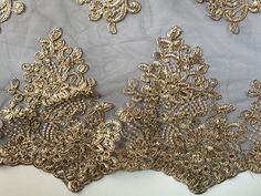 gold embroidered fabric with floral design on white background