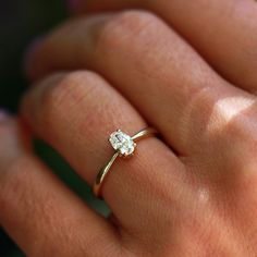 a woman's hand with a diamond ring on her finger, showing the center stone