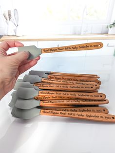 a person holding a wooden spoon in front of a stack of kitchen utensils