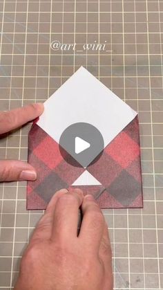 someone is cutting out an origami envelope