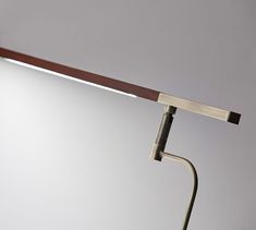 a desk lamp that is on top of a wooden table next to a white wall