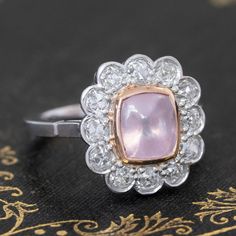 Cluster rings are a wonderful way to incorporate colored gemstones and diamonds into a piece of jewelry that is wearable just as is beautiful! A beautiful color contrast is this pink sapphire set in a halo of crisp, white old mine cut diamonds. The sugarloaf itself is bezel set in warm yellow gold, which kooks so pretty against the soft pink of the stone. All of the diamonds in platinum sparkle effortlessly, altogether making for the sweetest ring ever. Platinum and 18kt yellow gold bezel Size 6 Classic Pink Diamond Cluster Ring, Luxury Pink Gemstone With Center Stone, Oval Pink Platinum Jewelry, Pink Oval Platinum Jewelry, Formal Pink Diamond Cluster Ring, Classic Pink Cluster Ring With Center Stone, Fine Jewelry Pink Diamond Ring In Platinum, Classic Pink Cluster Ring With Halo Setting, Exquisite Pink Diamond Ring With Accents