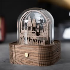 a wooden clock with a glass dome on it's stand and an image of people in the background