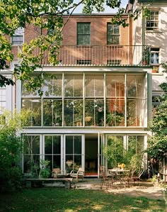 a large house with lots of windows on the front and side of it, surrounded by trees