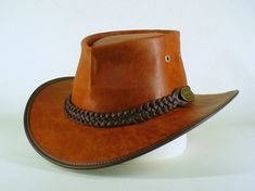 "AUSTRALIAN HAND CRAFTED BLACK / BROWN LEATHER OUTDOOR BUSH HAT ...THIS HAT IS HAND CRAFTED IN MELBOURNE,VICTORIA, BY THE LEATHER CRAFTSMAN  WHO ORIGINALLY INVENTED THE LEGENDARY FOLD-UP, \"DOUBLE SPRUNG\" AUSTRALIAN BUSH HAT => AUSTRALIAN PATENT NO.: 689 428   Hand made by John Whittaker, of Cobb & Co Hats & Accessories in Melbourne, Australia. We create a wide range of formal, outdoor & costume hats. Each hat is made to measure (to fit the individual customer). The Black or brown leather Bush Handmade Leather Hat With Flat Brim, Handmade Leather Brimmed Hat, Brown Hat With Waxed Finish And Curved Brim, Handmade Western Leather Hat, 5-panel Leather Hat For Outdoor, Handmade Brown Felt Hat, One Size, Brown Felt Hat For Rodeo, One Size, Brown Wide-brim Fedora With Feathers, Outdoor Hut