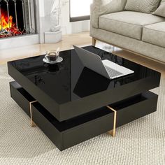 a black coffee table with a laptop on it in front of a fire place and couch