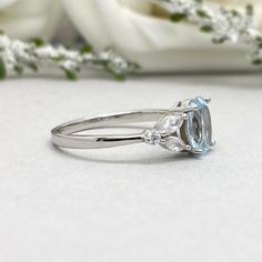 This beautiful ring is made from genuine 925 sterling silver with rhodium plating. Ring details- -The Main stone is an oval cut 8mm by 6mm Natural Aquamarine Stone -Side stones are 4mm by 2mm clear Marquise and 1.5mm Round simulated diamonds -Ring is casted in solid 925 sterling silver with rhodium plating (yellow gold and rose gold plated also available, please check the drop down menu for more options) -The Total face height of the ring measures 8mms and the band width measures 1.3mms -Each ri Peridot Engagement Rings, Original Engagement Rings, Simulated Diamond Rings, Art Deco Diamond Rings, Peridot Ring, Aquamarine Stone, Aquamarine Rings, Elegant Ring, Color Ring