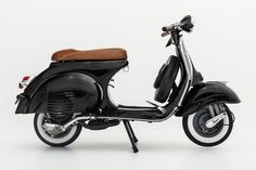 a black scooter with a brown seat is shown in front of a white background