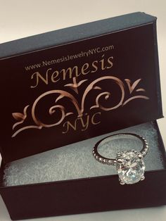 an engagement ring in a box with the name nemests nyc on it's side