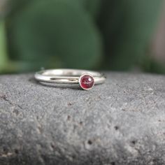 Garnet symbolizes love and is the gemstone to give for the 2nd anniversary. It is also the birthstone for January. This simple sterling silver stacking ring is a great gift, or an addition to a collection of stacking rings. Here are the details: This ring is made with a 4mm or 5-6mm bezel set garnet cabochon set on a sturdy sterling silver band handmade in your size. It can be worn with other stackable rings, or by itself.Please select your ring size. Sizes are US based. Classic Everyday Stackable Gemstone Rings, Classic Everyday Stackable Birthstone Rings, Classic Stackable Rings With Gemstones, Sterling Silver Stackable Rings, May Birthstone Gift, Classic Stackable Birthstone Ring For Promise, Classic Stackable Birthstone Promise Ring, Classic Everyday Sterling Silver Birthstone Ring, Stackable Ruby Ring With Round Band, Classic Stackable Birthstone Rings