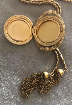 "Vintage A-C 12K Gold-filled Locket Tassel Lariat Pendant Necklace. Size: Necklace- 29\"x 3/16\"(3mm). Locket: 1\"x1 1/4\" round. Markings: A-C 1/20 12KT GF. Beautiful. Sold as is. Pre-Owned." Vintage Yellow Gold Jewelry With Detachable Pendant, Gold Tassel Jewelry For Evening, Gold Long Tassel Necklace, Gold Long Necklace With Tassels, Luxury Formal Tassel Jewelry, Antique Lariat Jewelry Gift, Elegant Yellow Gold Jewelry With Tassels, Elegant Medallion Locket Necklace With Adjustable Chain, Elegant Locket Necklace With Adjustable Chain