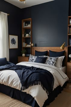 a bedroom with dark blue walls and white bedding is pictured in this image, there are bookshelves on either side of the bed