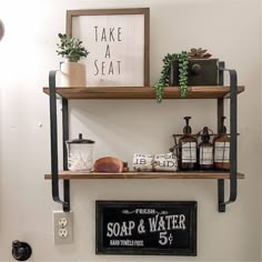 two shelves with soap and water on them in a bathroom next to a sign that says take a seat