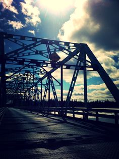 the sun shines brightly on an empty bridge