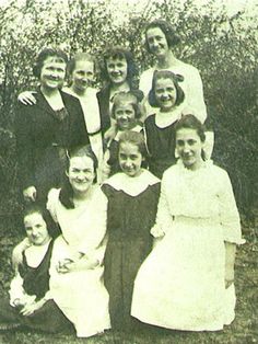 an old black and white photo of women in dresses posing for a group photograph together