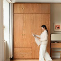 a woman in white is walking through the room