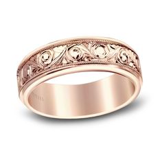 a rose gold wedding ring with scrolls on the sides and an intricate design in the middle