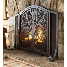 a fire place with a tree cutout on the front and sides, sitting next to a stone fireplace