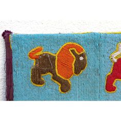 an embroidered piece with two elephants on it's side, one is red and the other is blue