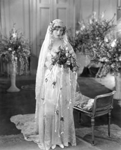 an old black and white photo of a woman in a wedding dress