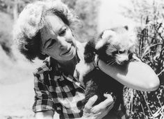 a woman holding a small kitten in her arms