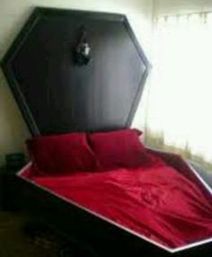 a bed with red sheets and pillows in a room