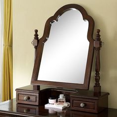 a mirror sitting on top of a wooden dresser