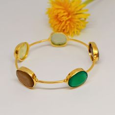 This exquisite Green Onyx, Smoky Quartz, Chalcedony and Citrine Bangle Bracelet combines elegance with unique charm, making it the perfect birthday gift for her. Crafted from high-quality 925 silver, this stunning silver bangle is plated with luxurious gold for a refined finish. Featuring a beautiful blend of green onyx, smoky quartz, citrine and chalcedony, this gemstone bangle is both striking and versatile. Ideal for daily wear or special occasions, this gold bangle is a must-have addition to Oval Jubilee Bracelet Bangle As Gift, Hallmarked Oval Bangle For Gift, Oval Gemstone Bangle As A Gift, Elegant Multicolor Bracelets For Birthday, Green Hallmarked Bracelet For Gift, Green Hallmarked Bracelet Gift, Chalcedony Bracelet, Chalcedony Earrings, Bangle Gold