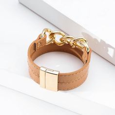 Add this stylish magnetic bracelet to your collection. Coordinate with gold jewelry or wear it alone as a statement piece. Order today and enjoy fast shipping. Trendy Gold Cuff Bracelet For Fashion, Adjustable Gold Leather Bracelet Chic Style, Adjustable Gold Leather Chic Bracelet, Trendy Gold Leather Bracelet, Trendy Brown Bangle Jewelry, Modern Gold Leather Bracelet, Trendy Brown Metal Bracelets, Chic Brown Bangle Bracelet, Elegant Brown Leather Bracelet