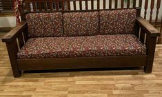 a wooden couch sitting on top of a hard wood floor