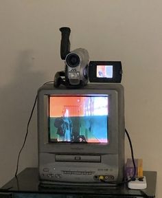 an old tv sitting on top of a table with a video camera attached to it