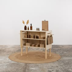 a table with bottles and boxes on it in the middle of a floor mat that looks like a rug