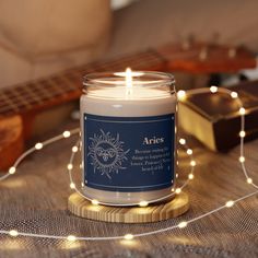 a candle sitting on top of a table next to a string of lights and a guitar