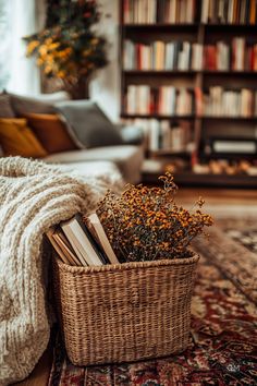 a wicker basket filled with books on top of a rug next to a couch