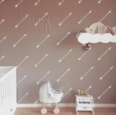 a baby's room decorated in brown and white with arrows painted on the wall