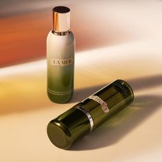 a bottle of la mer next to a tube of lotion on a white surface