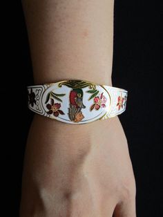 "This is a So Pretty Mid Century Vintage Gold Tone Metal With Colorful White Red and Forest Green Enamel Etched Embossed Dainty Rose Flowers Leaves Floral Leaf With Sitting Lion Tiger at The Center Hinged Bangle Cuff Bracelet The width of the bangle is one inch at the widest point; the opening measures 2 and a half inches at the bracelet's widest point, this piece will fits up to 7-1/2\" wrist. Very nice vintage piece and is in very good to excellent vintage condition with very little/minor sign Traditional White Bracelets For Ceremonial Occasions, White Cuff Bangle As Gift, White Cuff Bangle For Gift, White Cuff Bangle Suitable As A Gift, Traditional White Cuff Bracelet Bangle, Traditional White Cuff Bracelet (bangle Style), Traditional White Cuff Bangle Bracelet, Traditional White Bangle Cuff Bracelet, Traditional White Bangle Bracelet