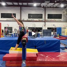 a woman standing on top of a trampoline in a gym