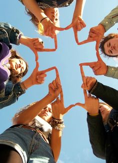 a group of people standing in a circle with their hands holding up the shape of a star