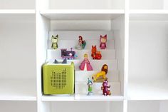 there are many toy figurines on the shelves in this room with white walls