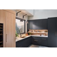 a kitchen with black cabinets and white counter tops