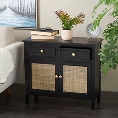 a black sideboard with wicker doors and drawers next to a white couch in a living room