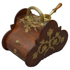 an ornate wooden box with gold decorations on it's sides and handles, holding a wine bottle